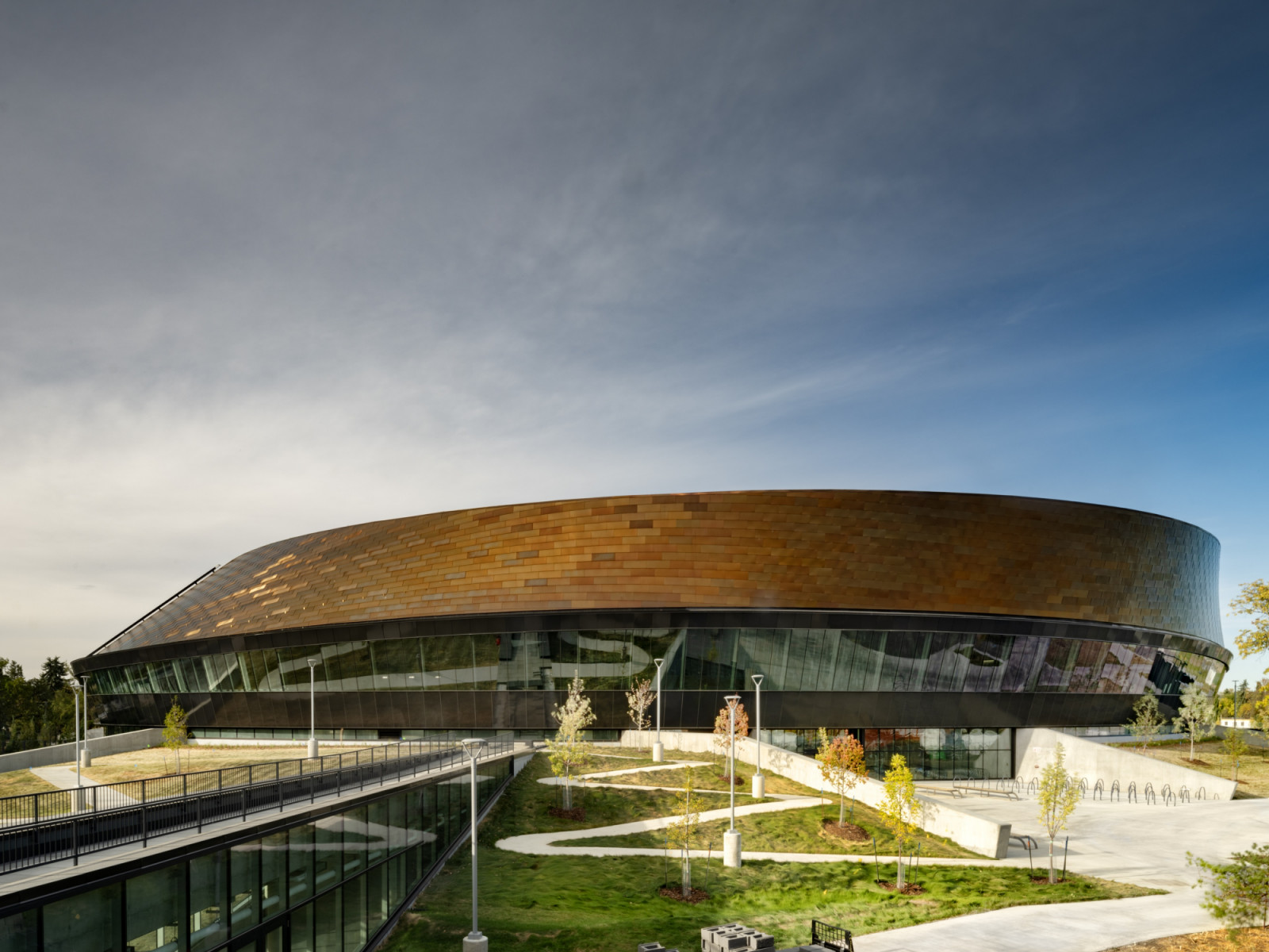 Shortlisted for the Prix Versailles Most Beautiful Arenas 2026, the centre's ribbon-wall envelope twists to follow the velodrome's interior geometry (Photo: Nic Lehoux)