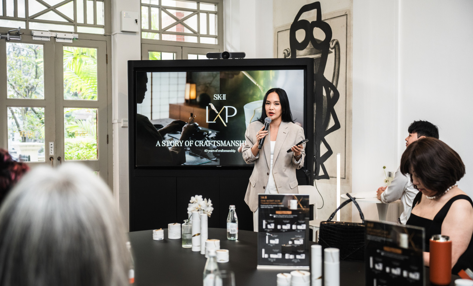 A presenter introduces the SK-II LXP collection, highlighting its 40 years of craftsmanship at a special event.