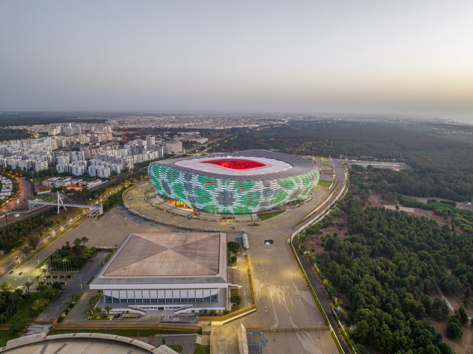 At night the envelope becomes an animated screen, lit here in green and white (Photo: Société des Infrastructures Sportives de Rabat)