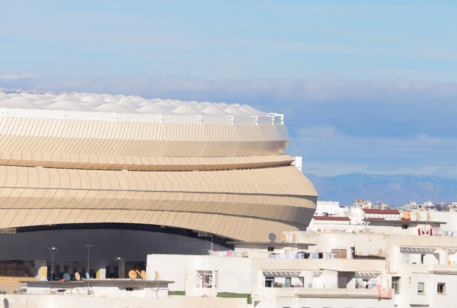 The canopy’s membrane domes crest the stadium’s outer envelope, set against the rooftops of the city known as the Bride of the North. (Photo: Morocco lens)