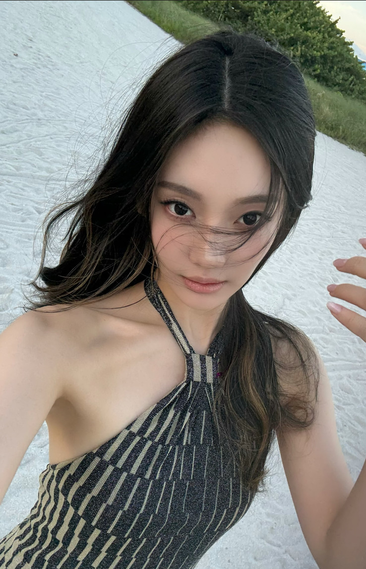 Ningning of aespa on the sand, showcasing her effortless style in a patterned halter top.