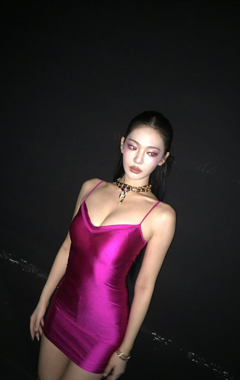 aespa's Ningning embodies her signature glamour in a fuchsia slip dress and a striking serpent necklace.