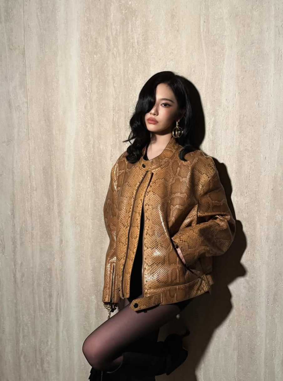 aespa's Ningning models a luxurious snakeskin jacket, complemented by statement gold earrings.