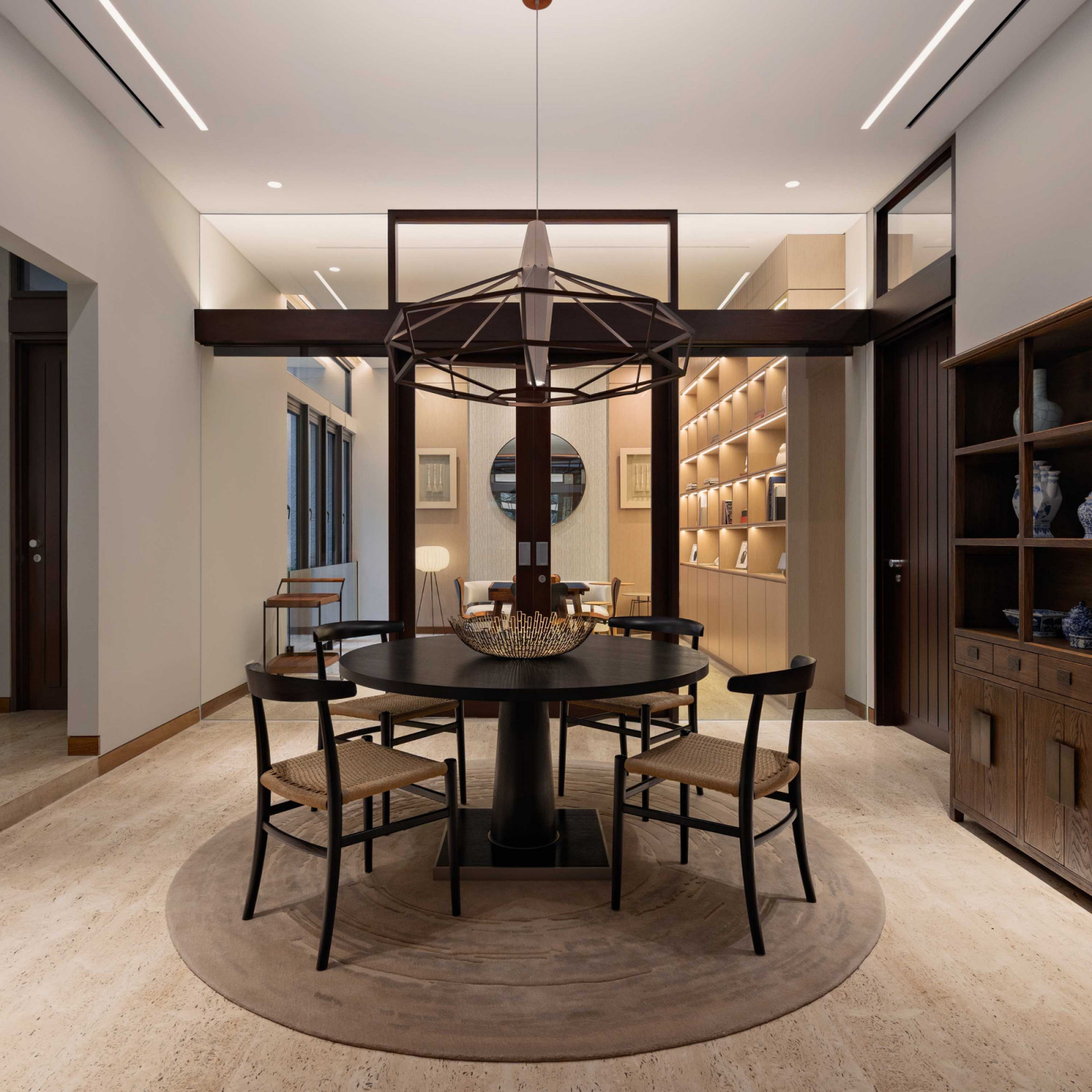 A circular pendant lamp echoes the form of the table below