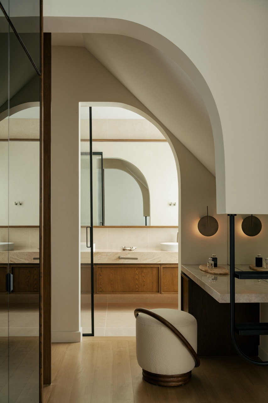 An arched  opening leads to a vanity area