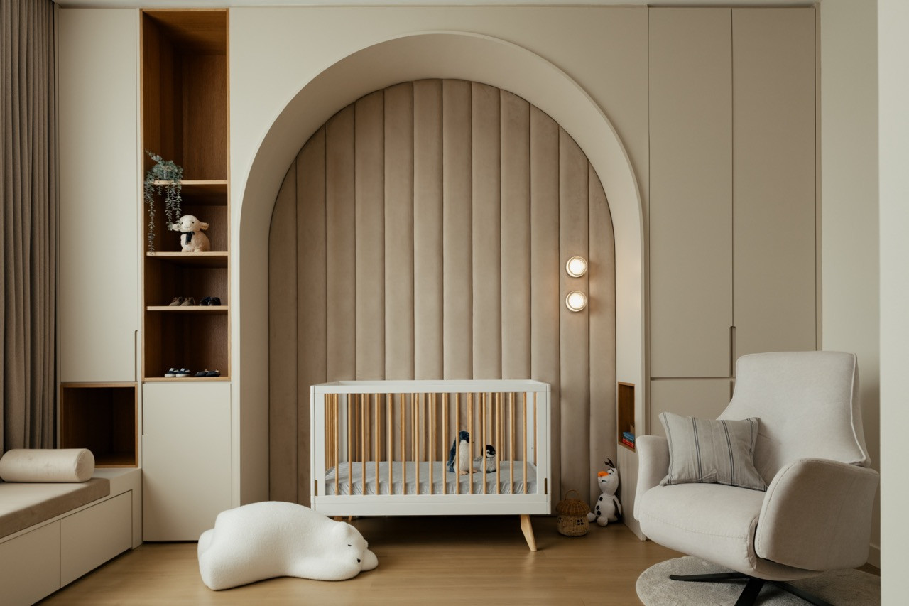 The nursery, with a padded arched wall and open shelving in white oak, is ready for the family’s second child
