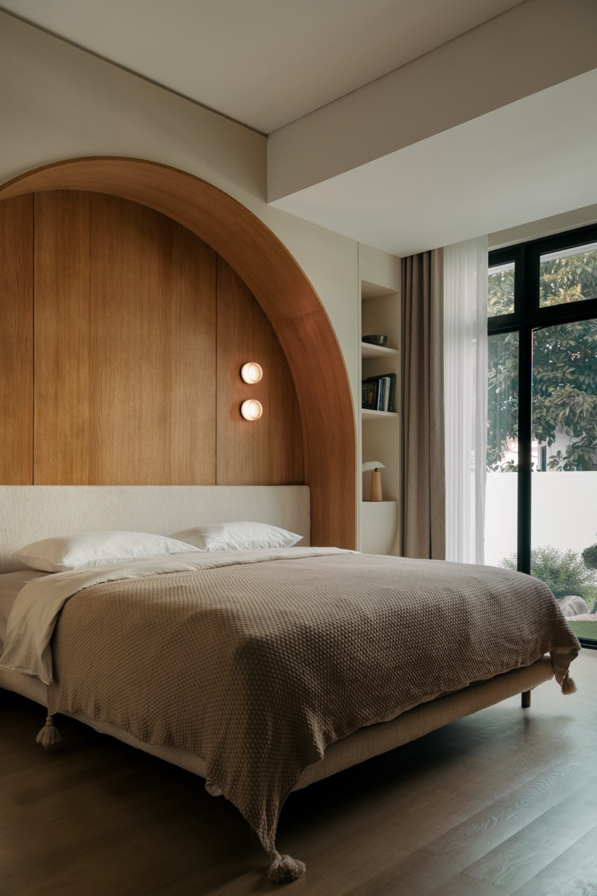 A bedroom with an arched  timber headboard