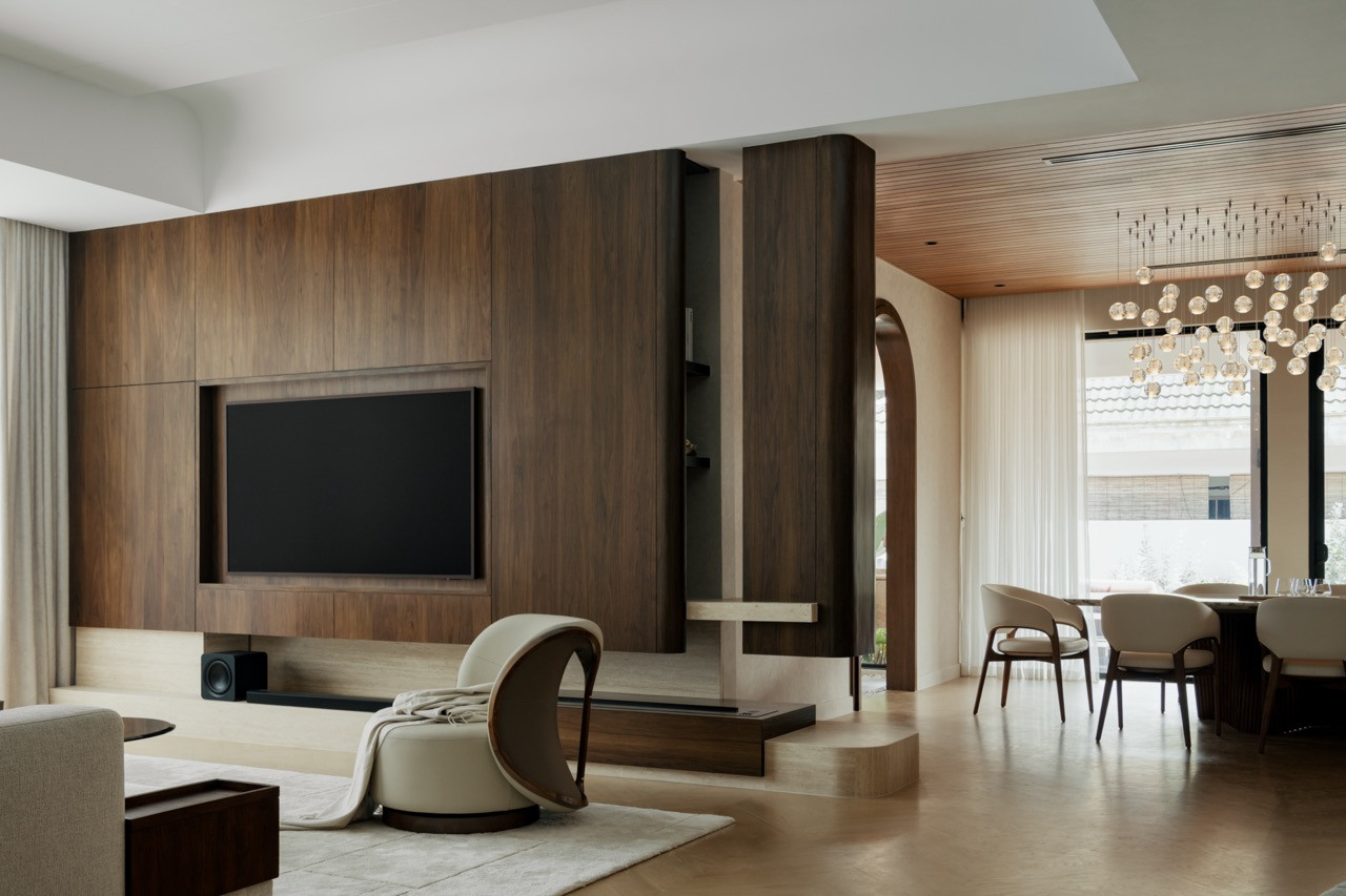 Walnut panelling wraps the TV wall in the living area, which flows into the dining room
