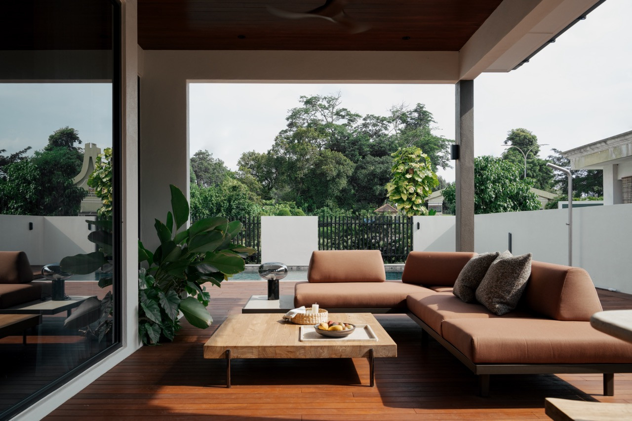 Low-slung sofas from King Living furnish the covered terrace overlooking the pool and garden