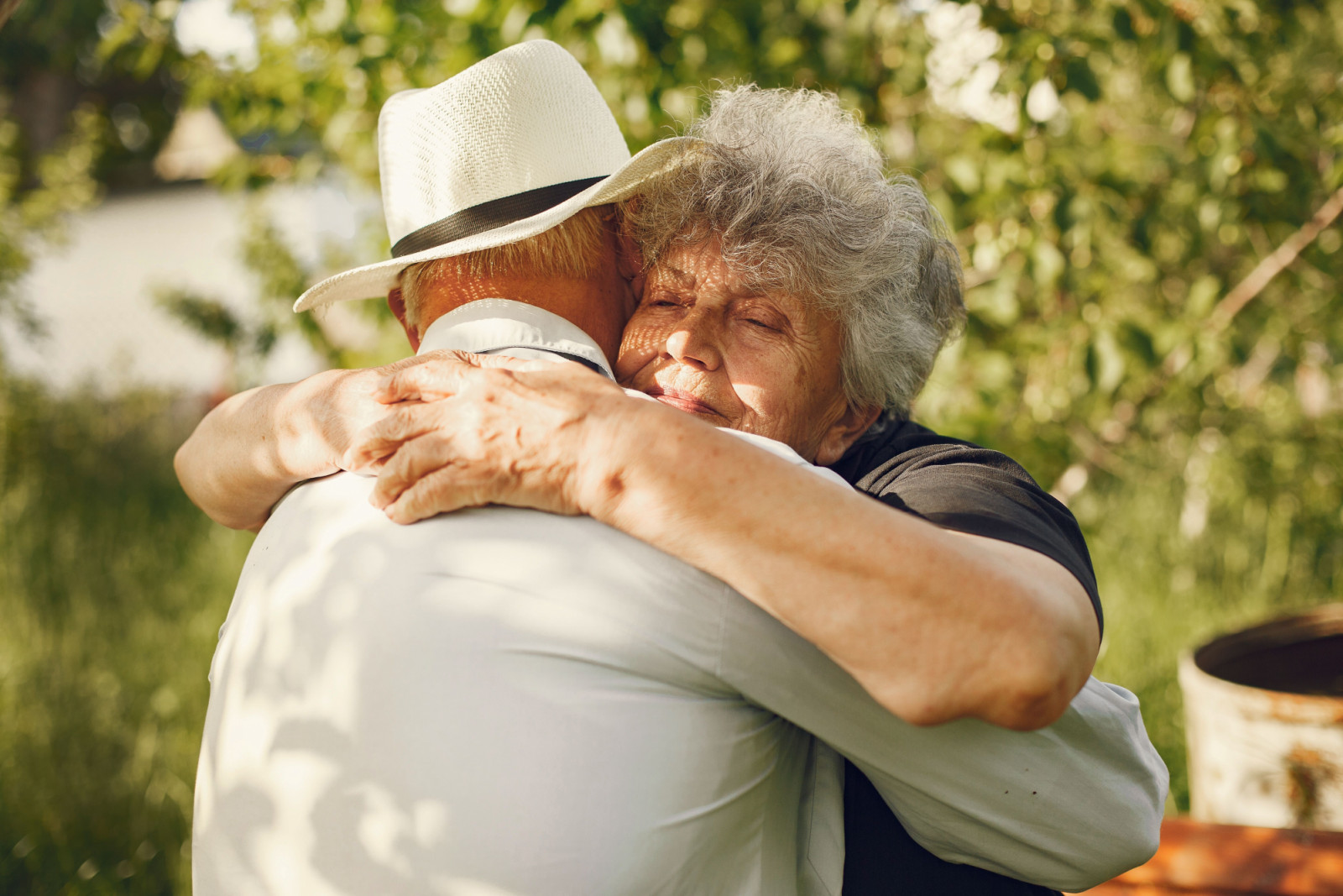 An elderly couple shares a tender embrace, reflecting the enduring connections of a lifetime.