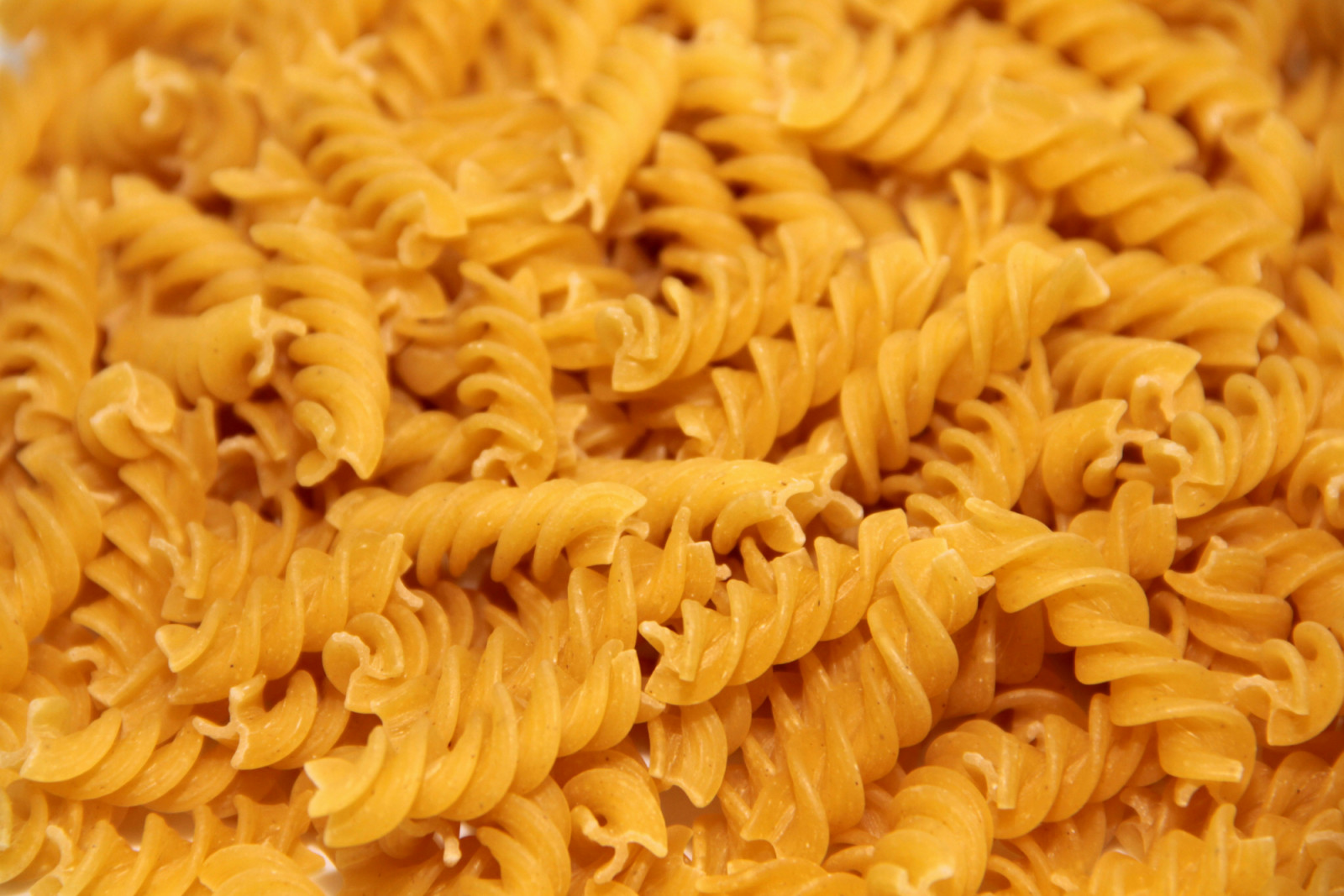 Fusilli pasta features its signature corkscrew shape, perfect for holding sauces and adding texture.