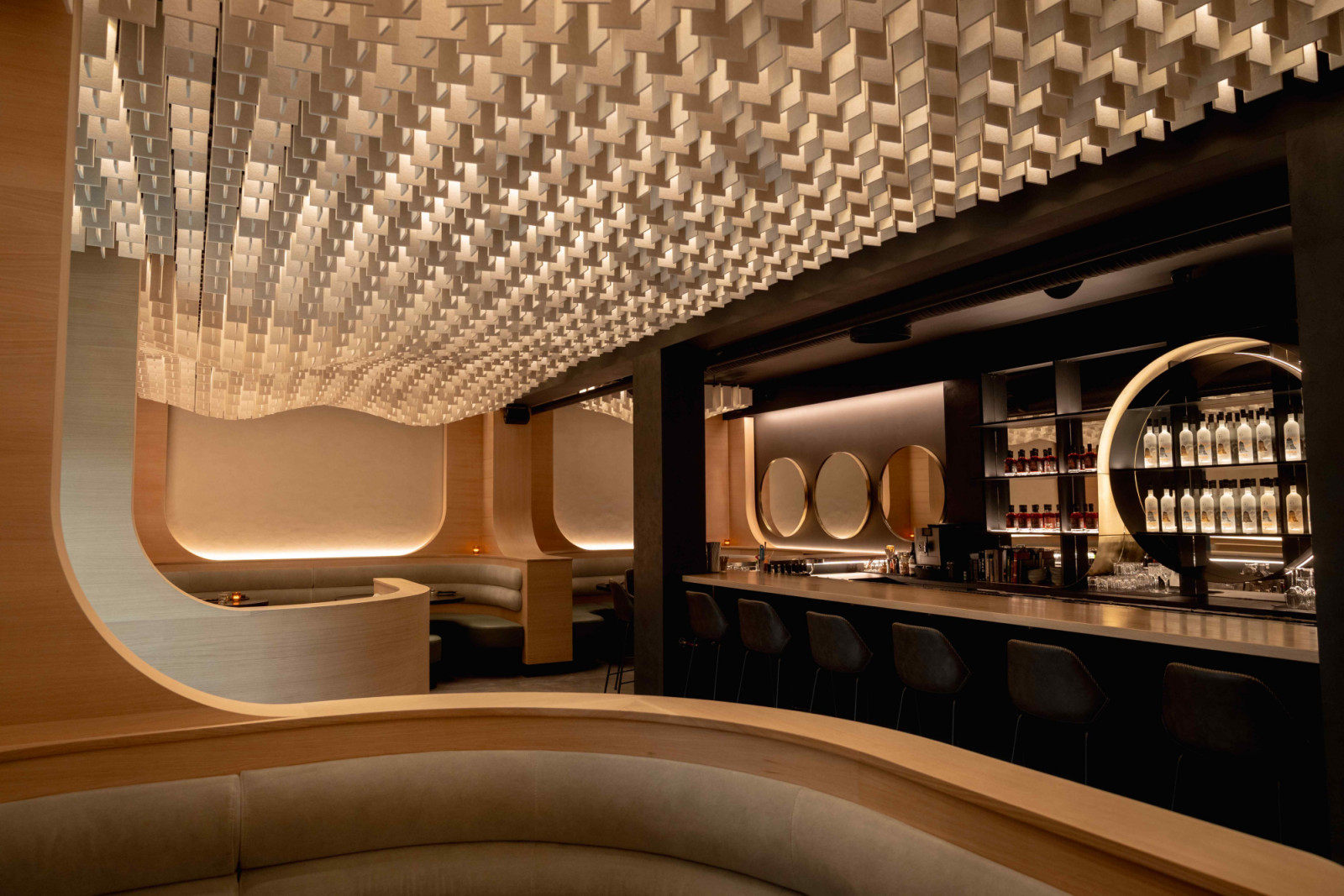 The striking parametric ceiling of curved acoustic fins creates a sculptural canopy