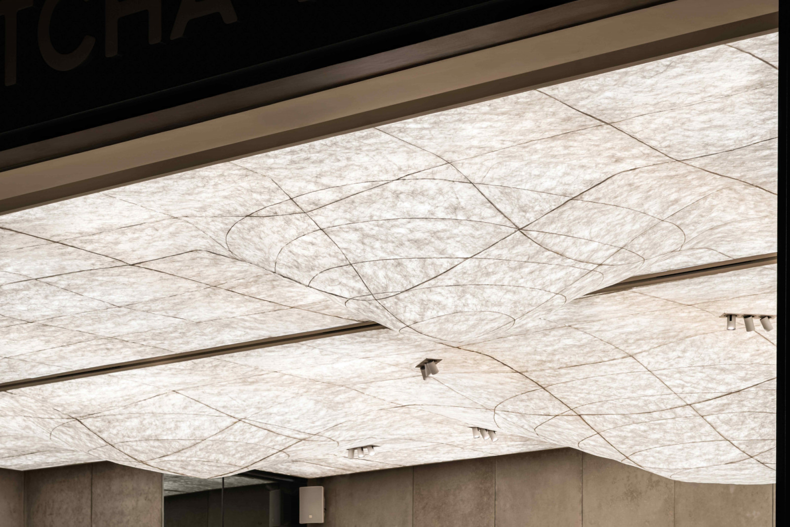 The sculpted ceiling evokes the foam formed by whisking matcha