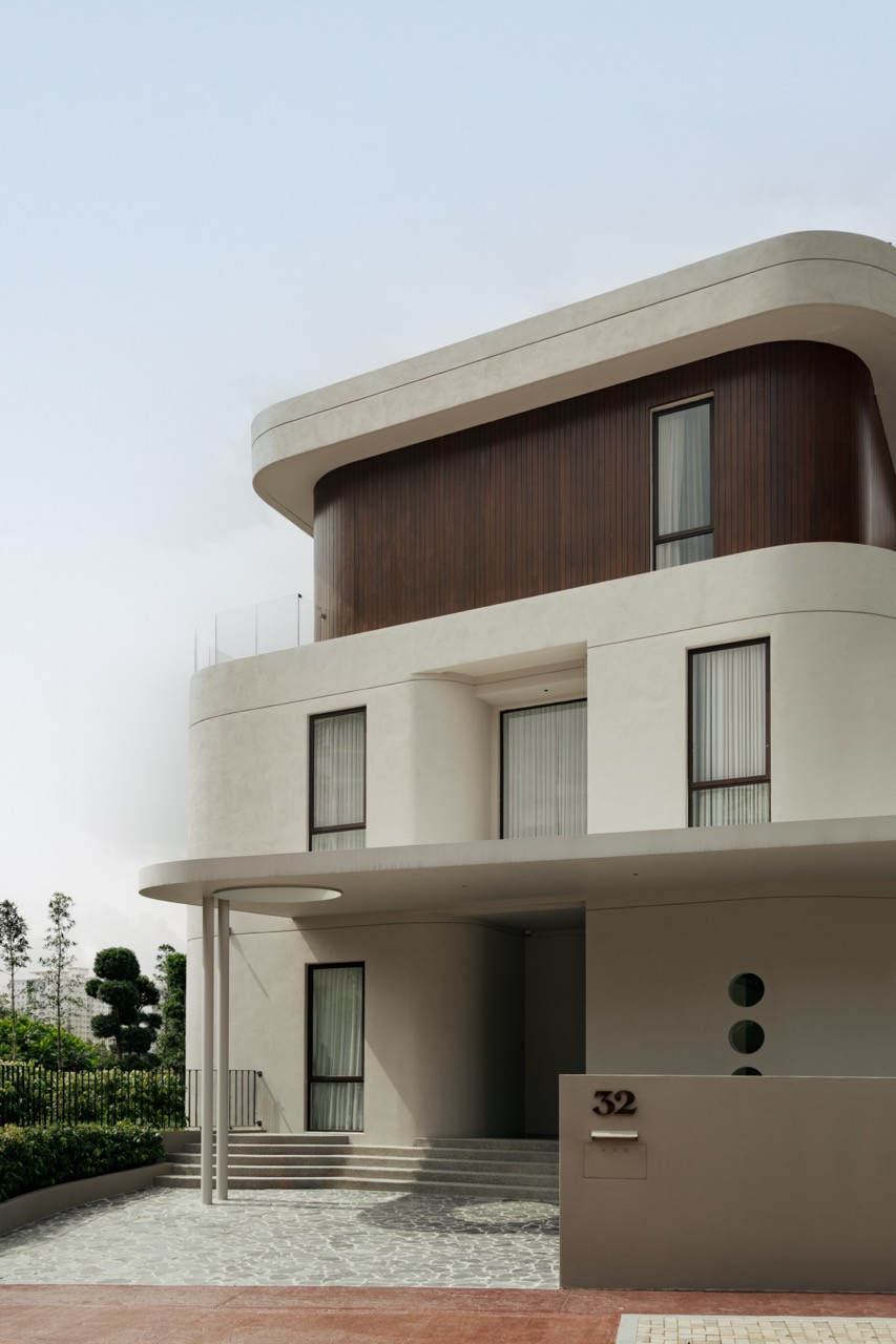 The bungalow’s façade in Mont Kiara, its rounded concrete form wrapped in dark timber cladding