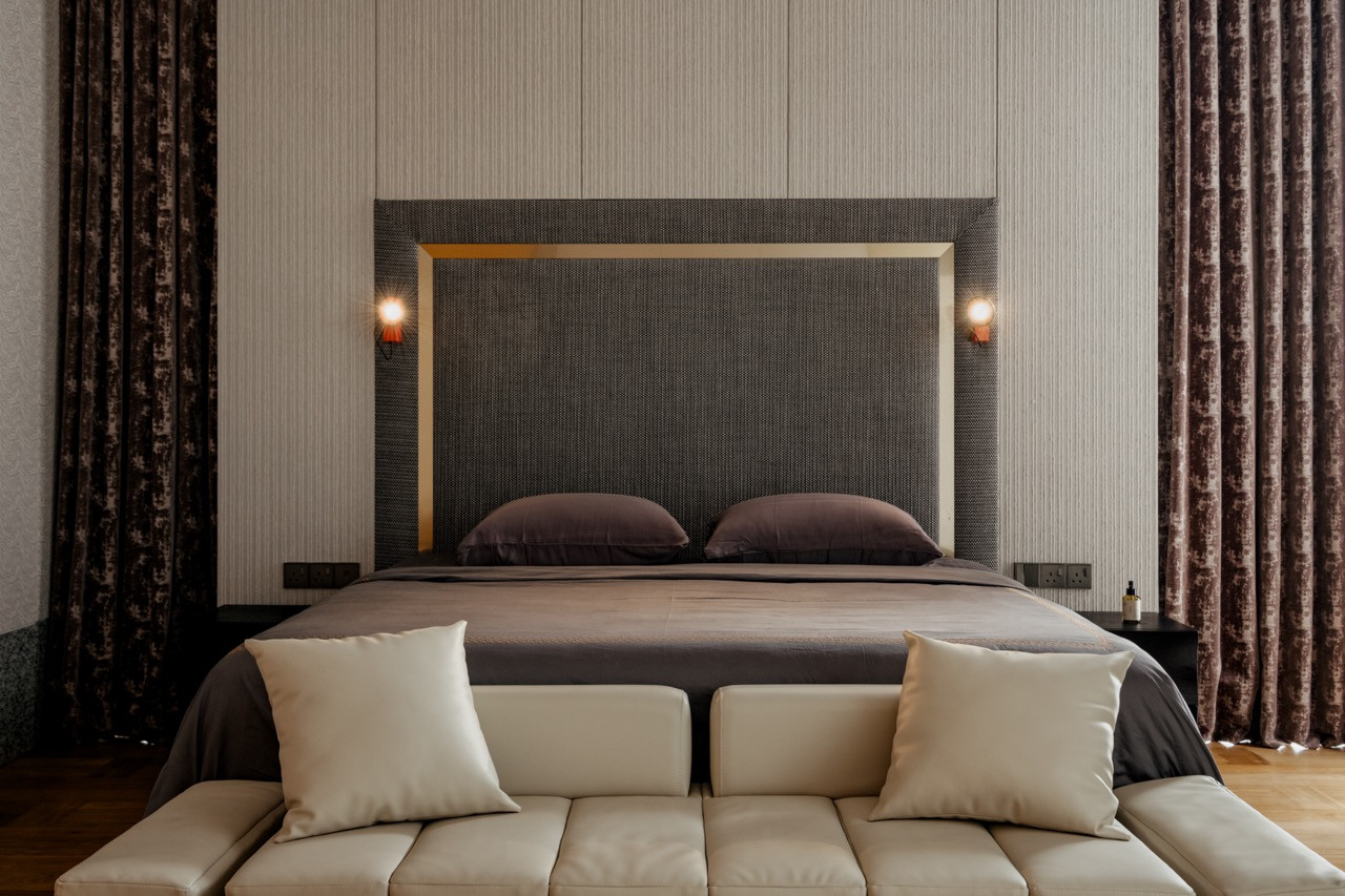 The master bedroom’s upholstered headboard and sofa-style bench seating, framed by the curved ceiling