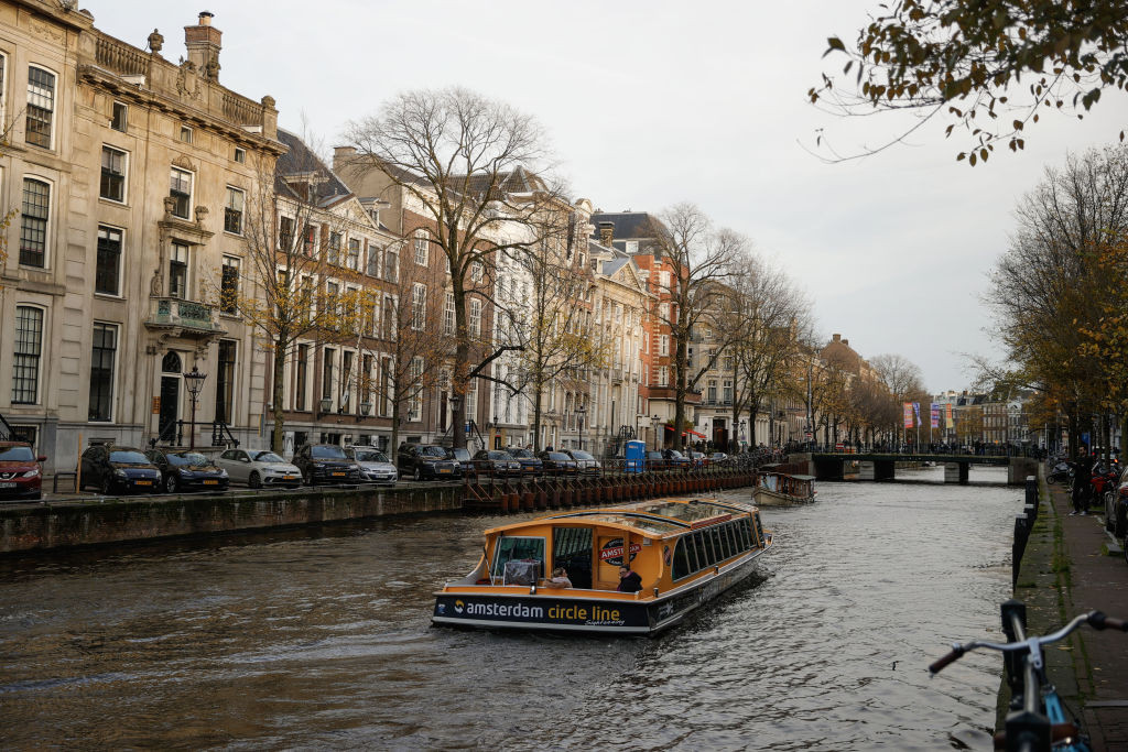 A city sightseeing boat is seen on a canal during daily life in Amsterdam, Netherlands on November 24, 2024. The city attracts tourists with its historical buildings and canals running through the city. (Photo by Esra Hacioglu Karakaya/Anadolu via Getty Images)