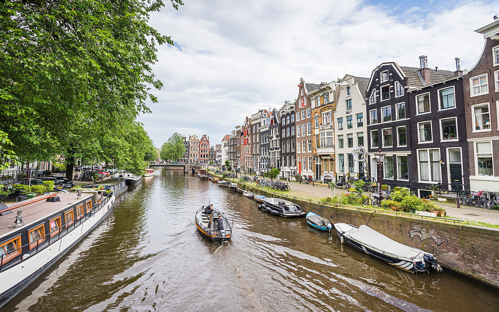 Boat travels on the pretty Prinsengracht canal. (Photo by: Jason Wells/Loop Images/Universal Images Group via Getty Images)